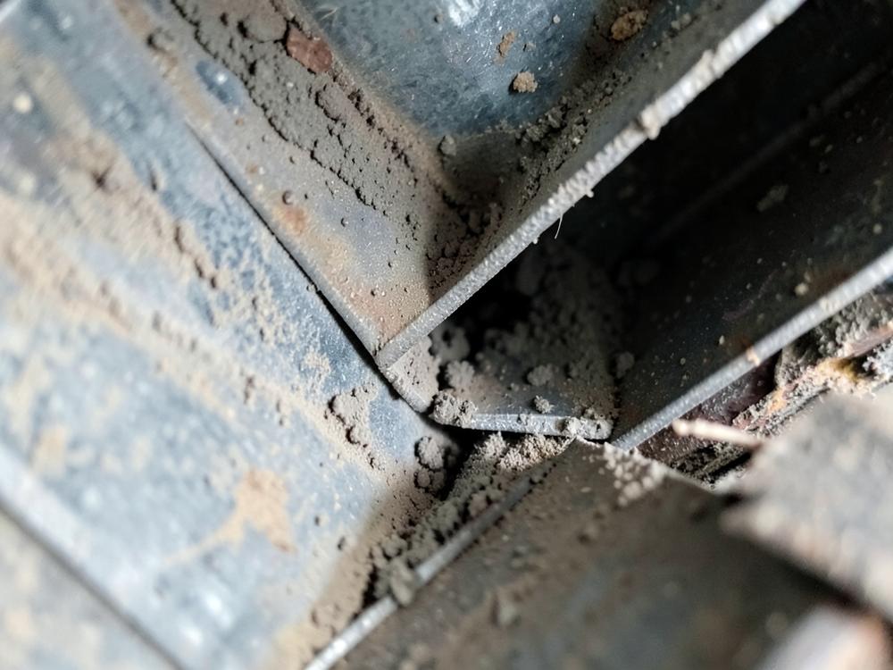 Dust and debris built up inside a residential air duct before cleaning